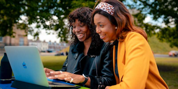 two girls looking at a laptop